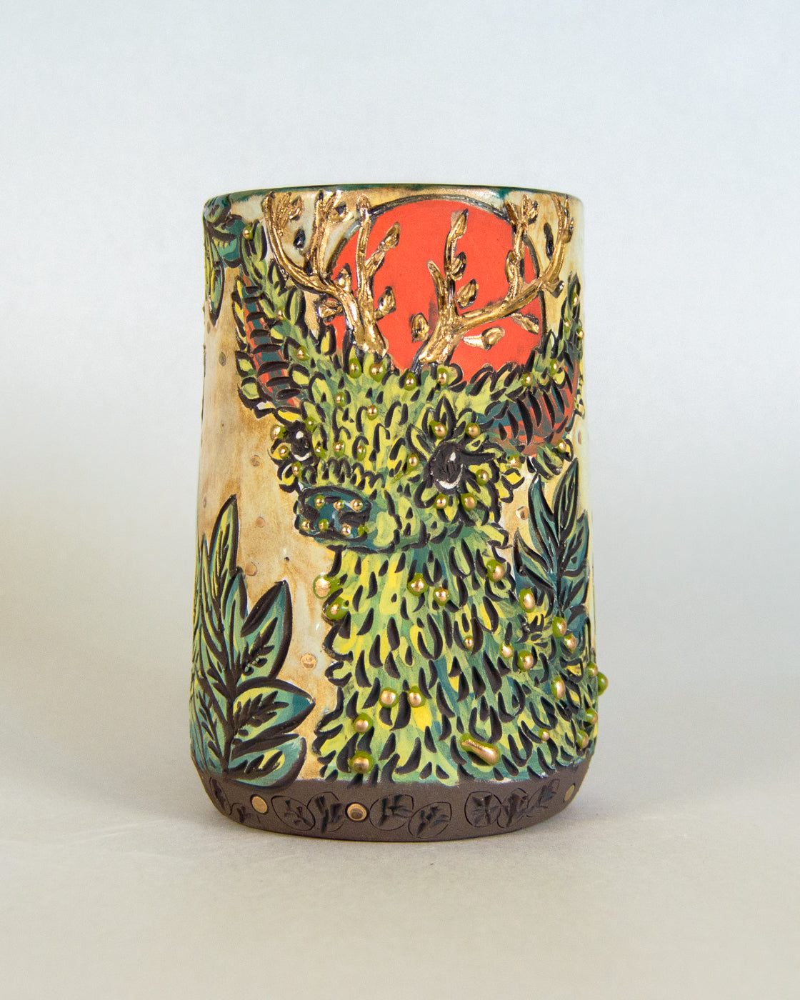 Ceramic mug with deer and foliage design on a white background