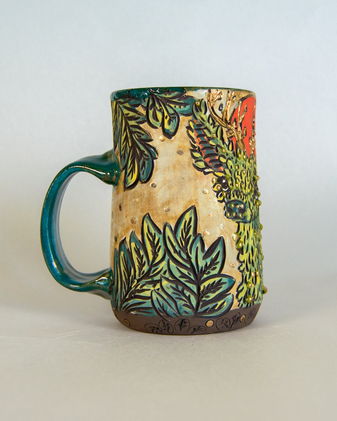 Ceramic mug with leaf patterns on a white background