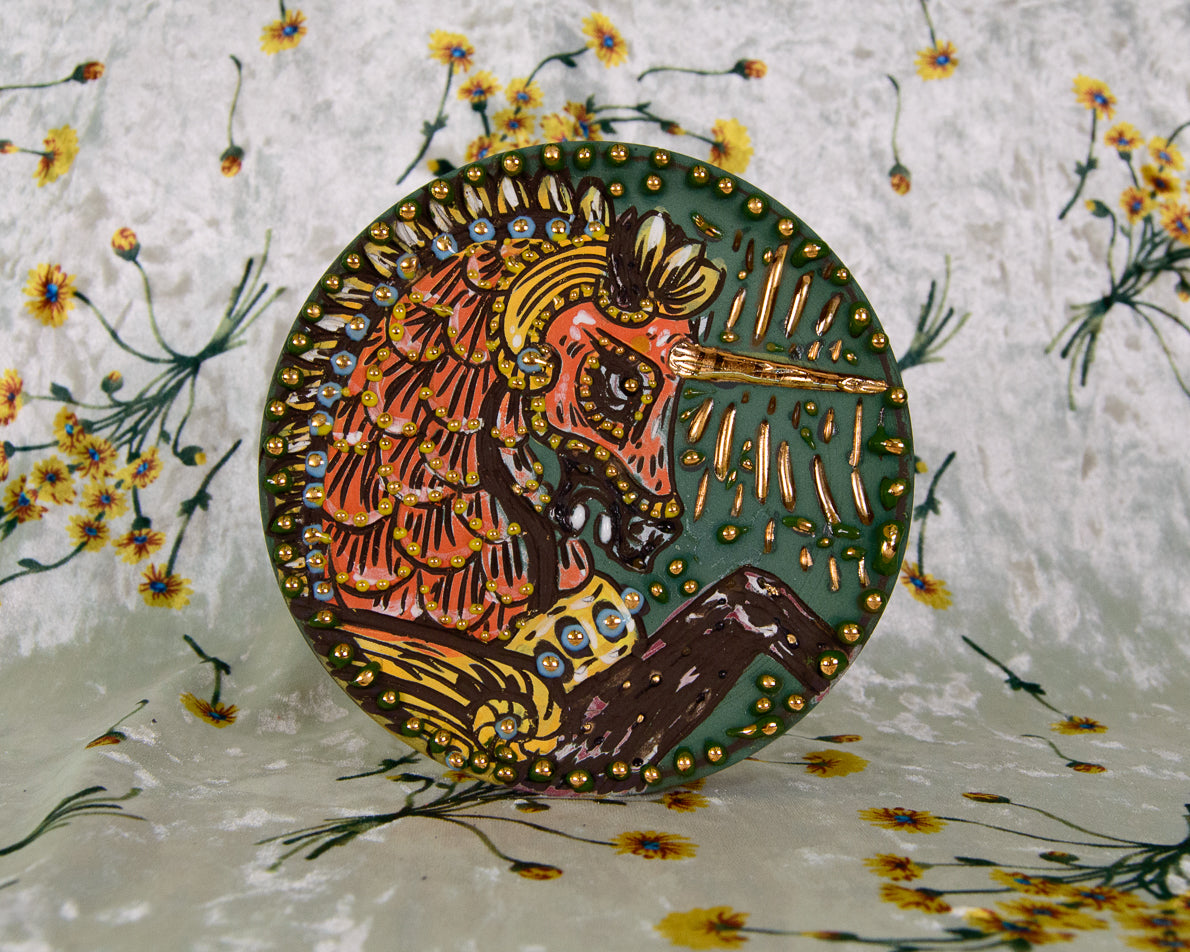 Decorative, handmade ceramic coaster with a stylized Carousel Horse design with textured gold details. 