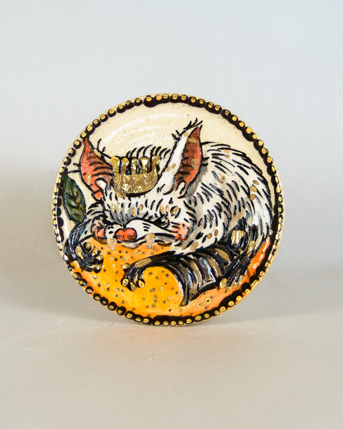 Ceramic coaster with bat and orange design
