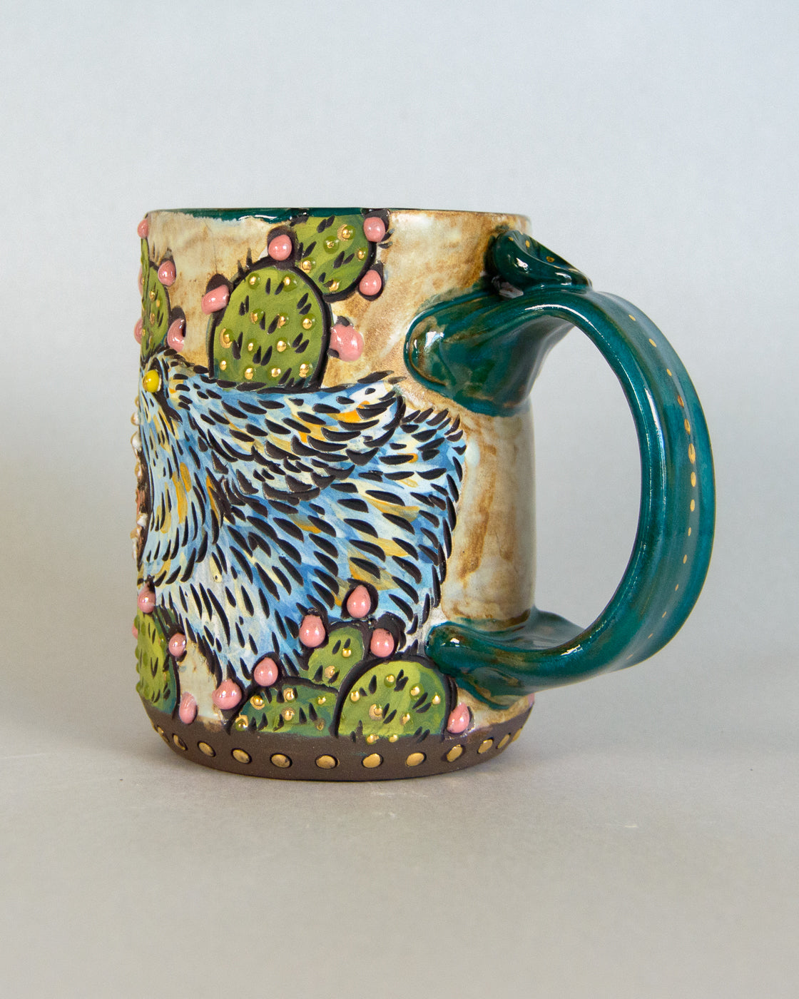 Ceramic mug with a colorful design of a coyote and cacti on a plain background