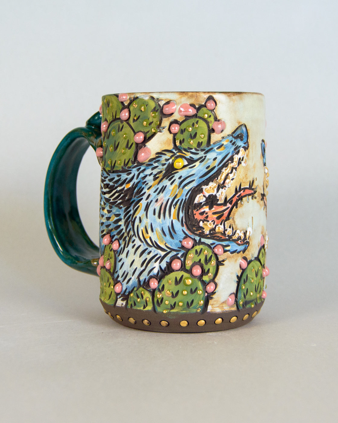 Ceramic mug with a coyote and cactus design on a white background