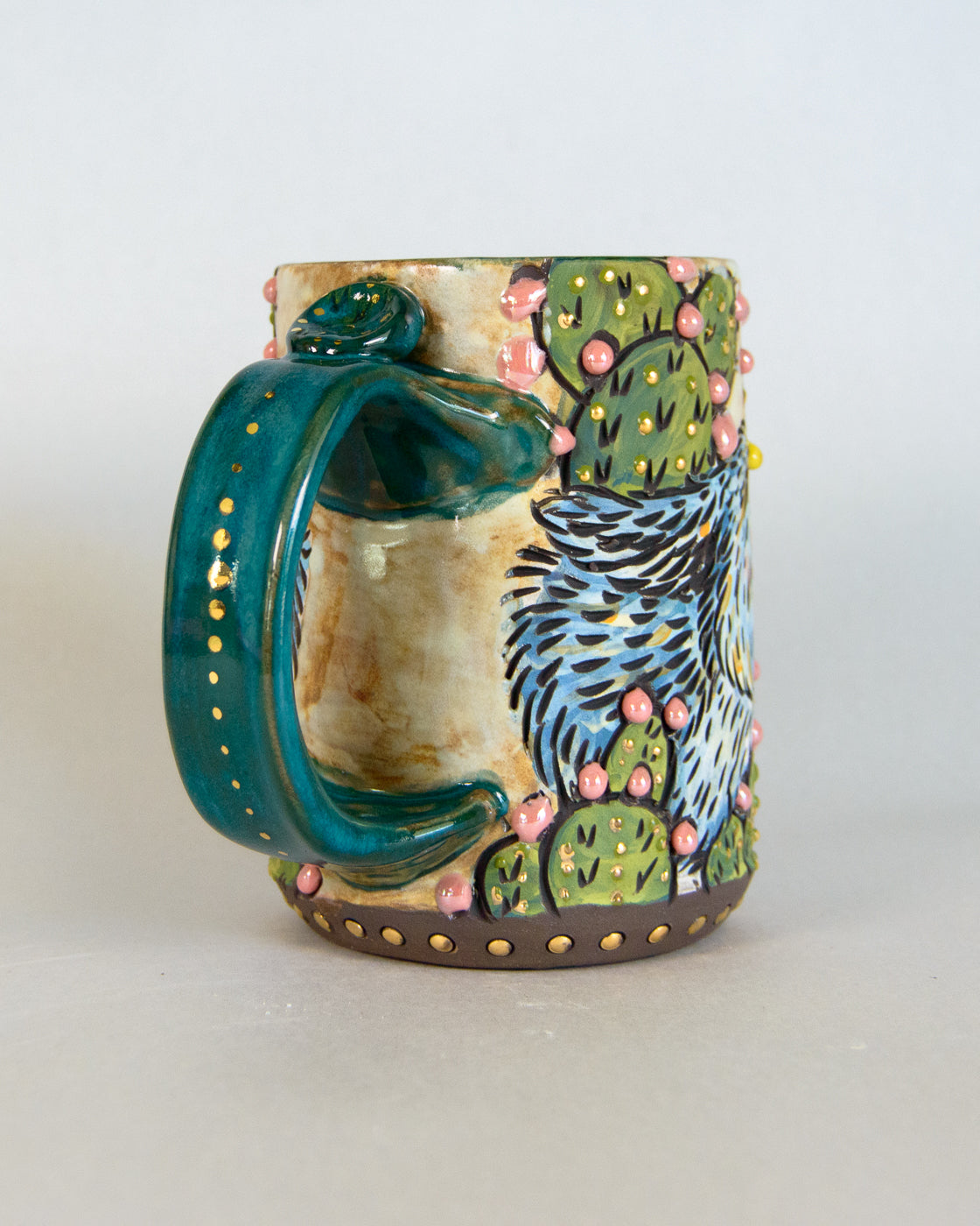 Ceramic mug with a colorful cactus design on a white background