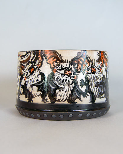 Ceramic pot with artistic bat design on a light gray background