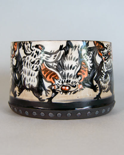 Ceramic planter with bat design on a plain background