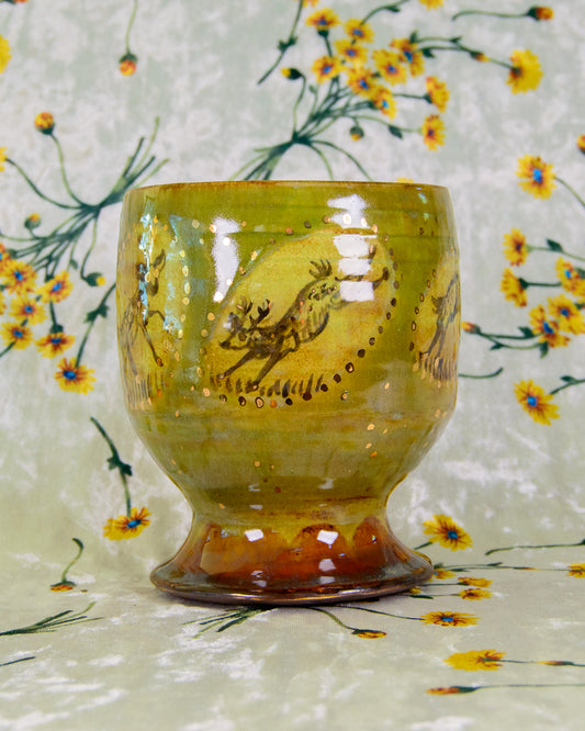 Ceramic cup with a deer design on a floral-patterned background