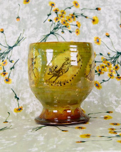 Decorative ceramic cup with deer design on a floral background