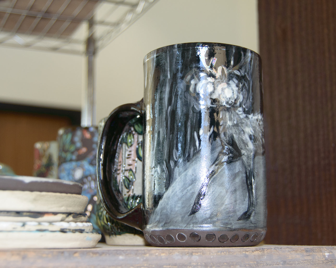 Ceramic mug with a deer design on a wooden surface