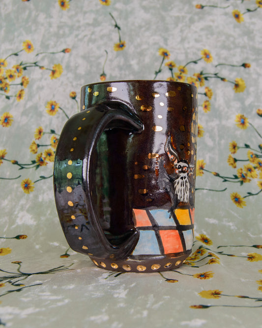Ceramic mug with gold designs on a floral-patterned background