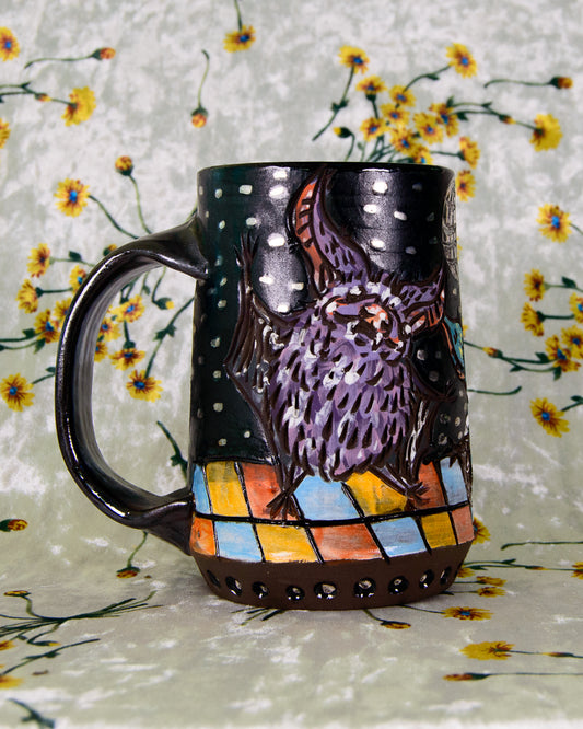Black matte mug with purple dancing bat designs on a dance floor with silver accents