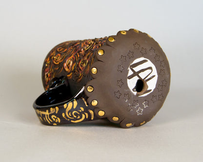 Decorative ceramic planter with gold accents on a light gray background