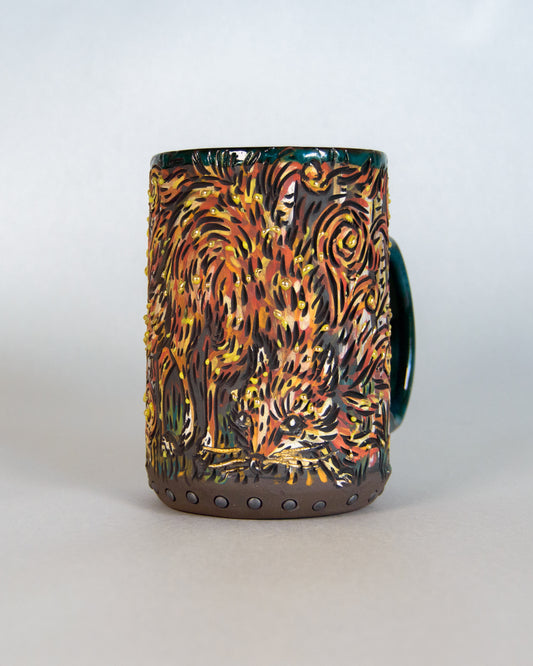 Ceramic mug with a fox and fire design on a white background