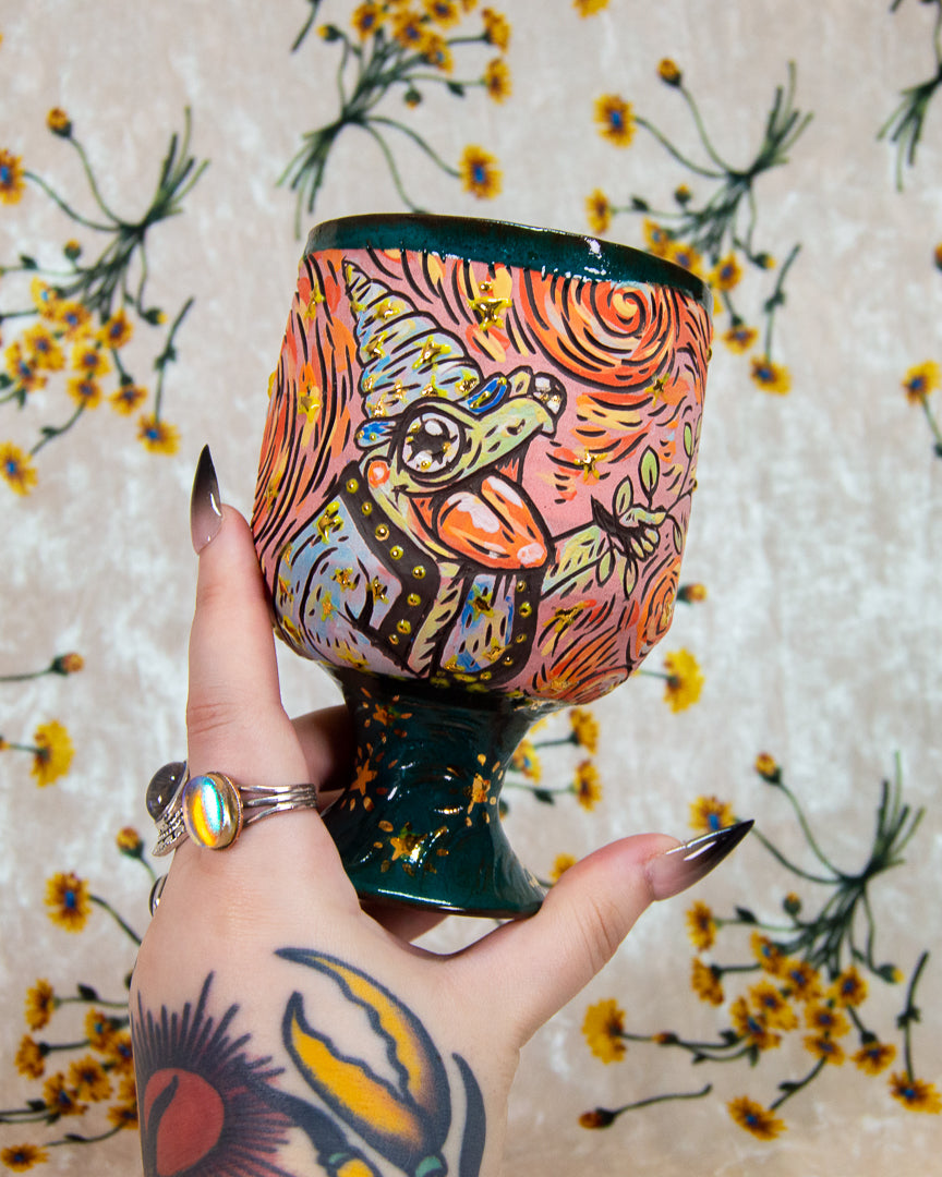 Handmade ceramic cup with a colorful cartoon frog wizard design