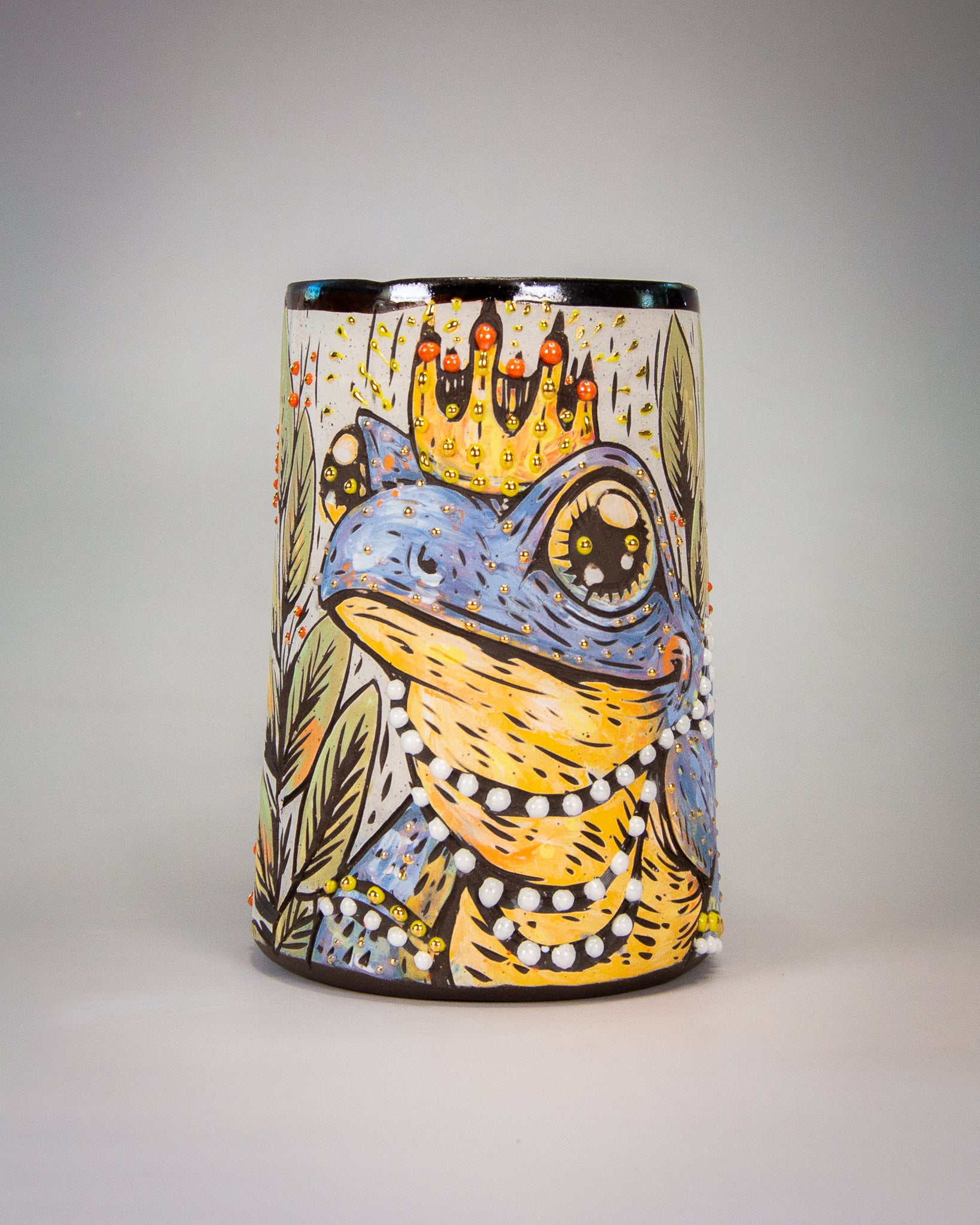 Colorful handmade ceramic mug with a stylized frog wearing a crown, the frog princess