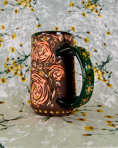 Black stoneware mug with cartoon magic swirl designs and gold luster shiny stars on a blue handle