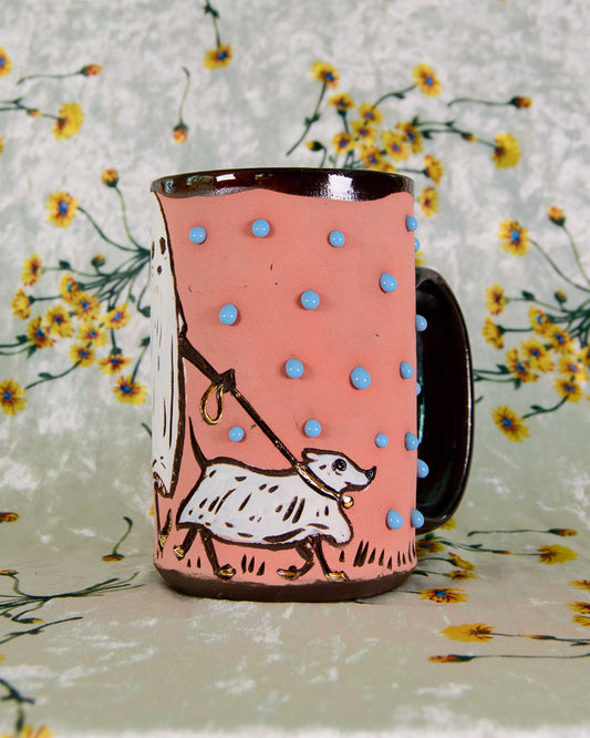 Pink mug with blue polka dots and a ghost  dog illustration on a floral background