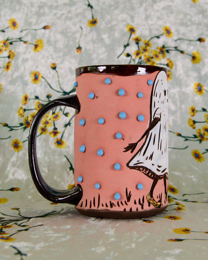 Mug with polka dot design and character illustration on a floral background