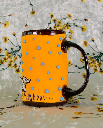 Orange mug with blue polka dots and a brown handle on a floral background