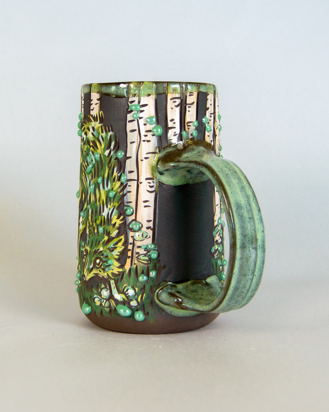 Ceramic mug with nature-themed design on a white background