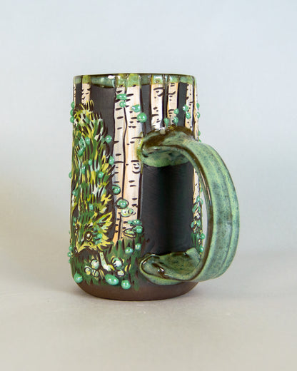 Ceramic mug with nature-themed design on a white background