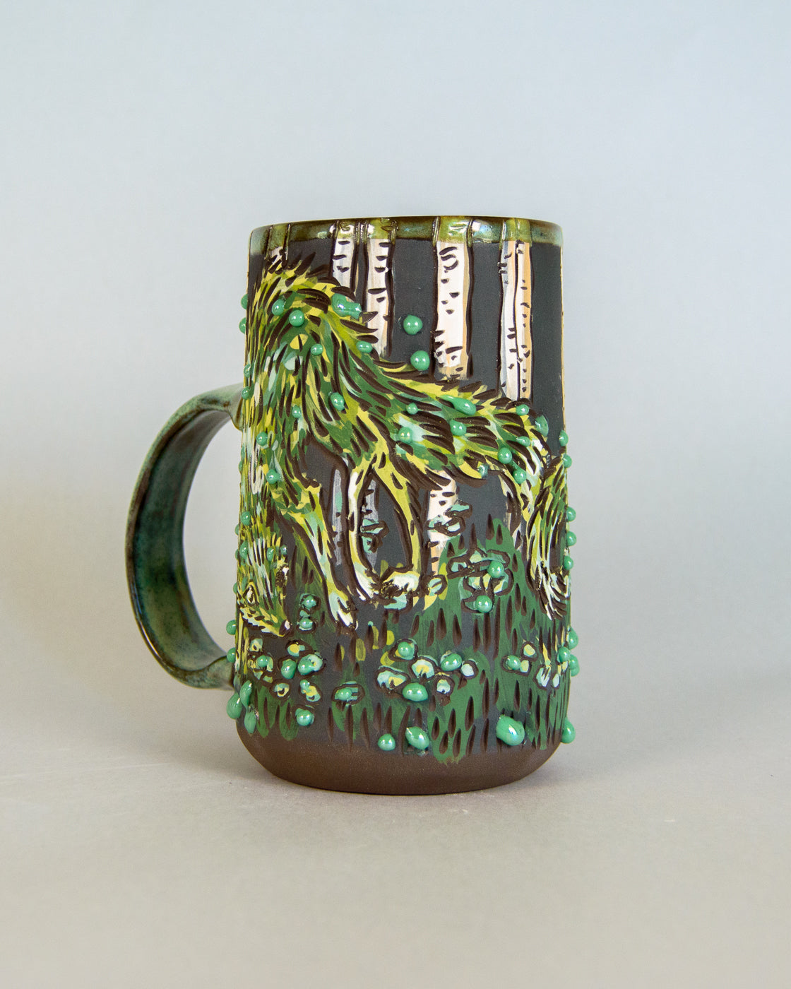 Ceramic mug with nature-themed design on a light gray background