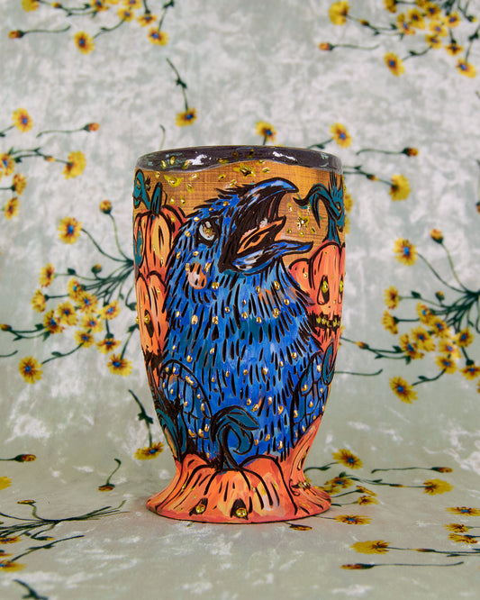 Decorative tumbler with a colorful bird and pumpkin design on a floral background