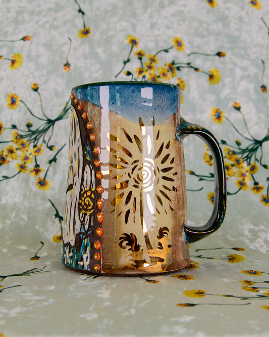Decorative mug with golden flower designs on a floral background