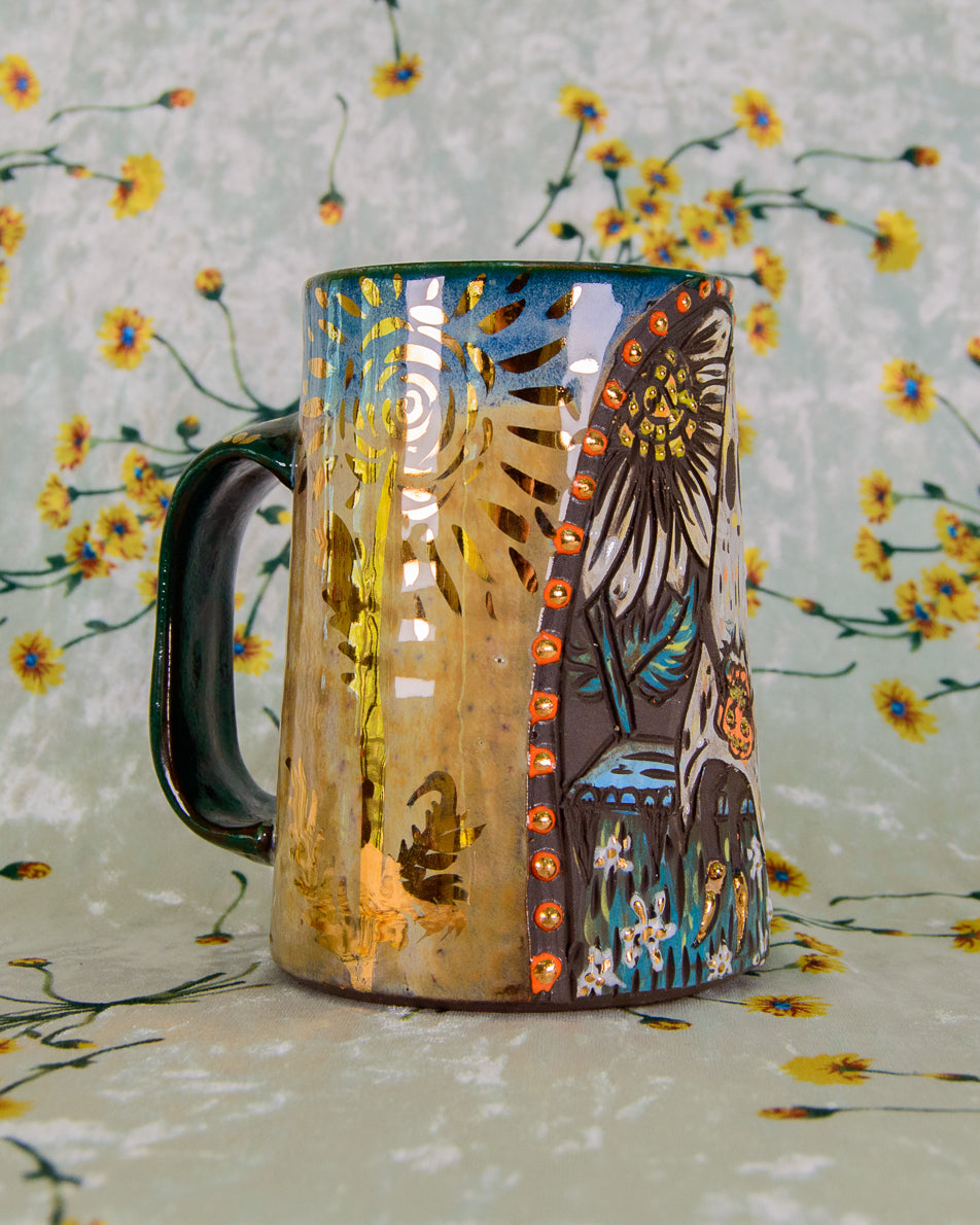 Colorful ceramic mug with gold flower design on a floral background