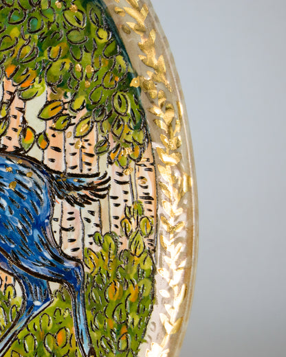 Decorative plate with a gold leaf design on a plain background