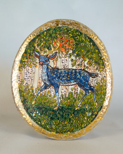 Decorative plate with a deer in a forest design on a white background