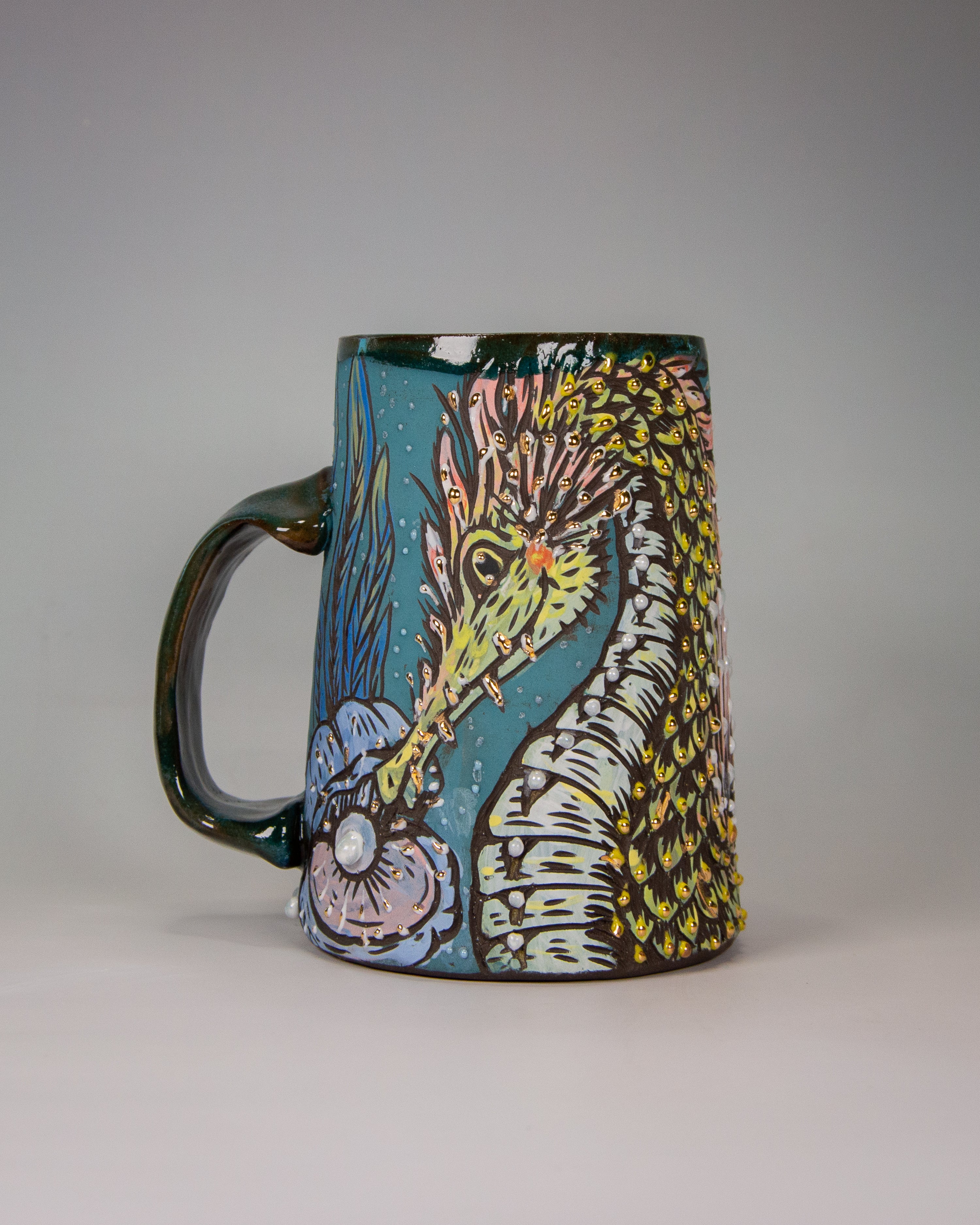 Colorful handmade ceramic mug with a cute cartoon sea dragon design