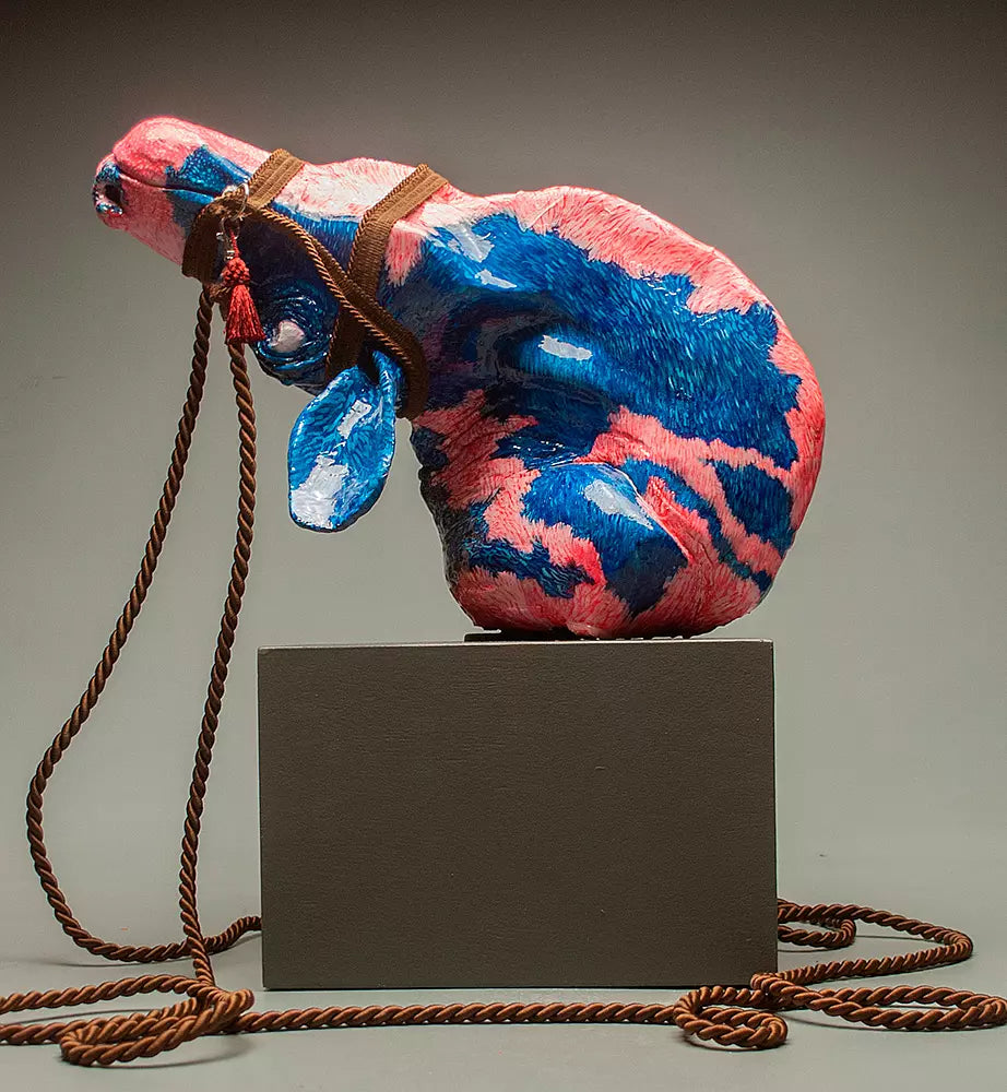Pink and Blue ceramic sculpture of a monstrous cow wearing a bridle