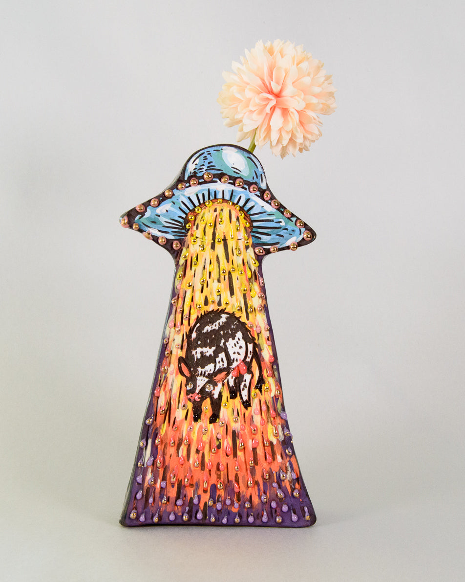Handmade ceramic vase shaped like a ufo decorated with colorful cow designs