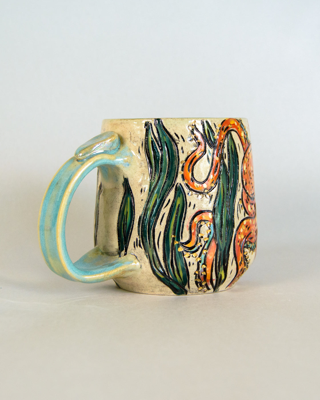 Ceramic mug with a colorful octopus design on a light gray background