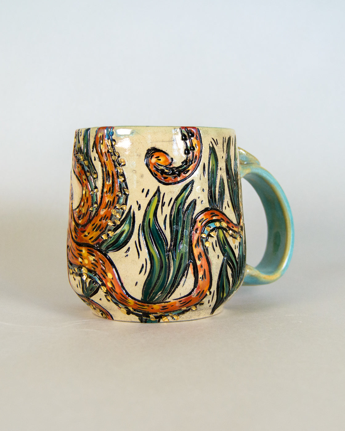 Ceramic mug with artistic octopus design on a plain background