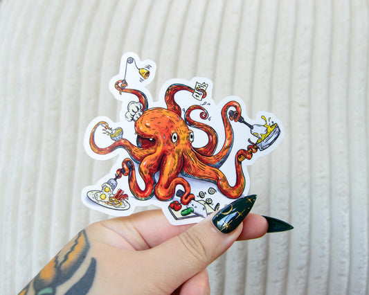 Sticker of an illustrated octopus chef with various cooking utensils like spatulas, knives, and pans held by a hand against a textured white background