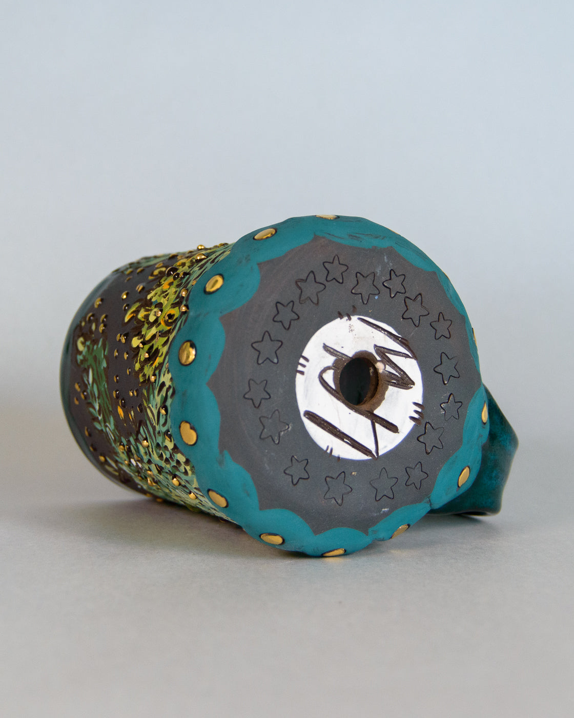 ceramic planter with star patterns and a LAW logo design on a light gray background