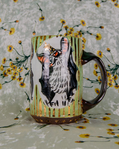 green black and white ceramic mug with a cute cartoon bat design and gold details