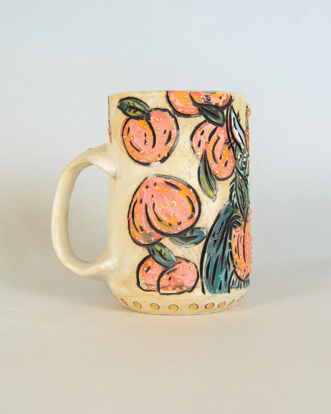 Ceramic mug with peach and bat design on a light background