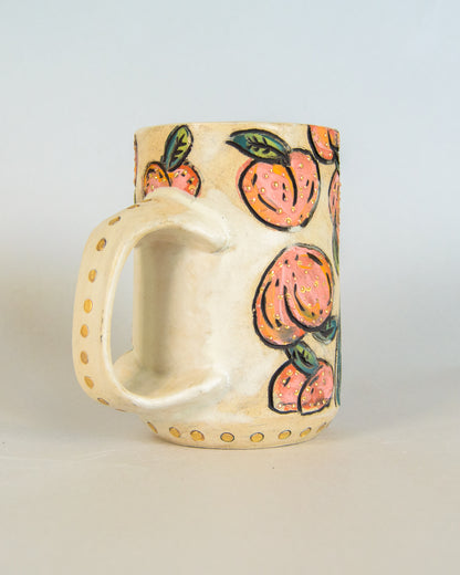 Ceramic mug with peach designs on a light gray background