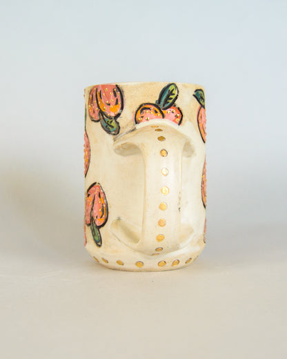 Ceramic mug with peach patterns on a light gray background