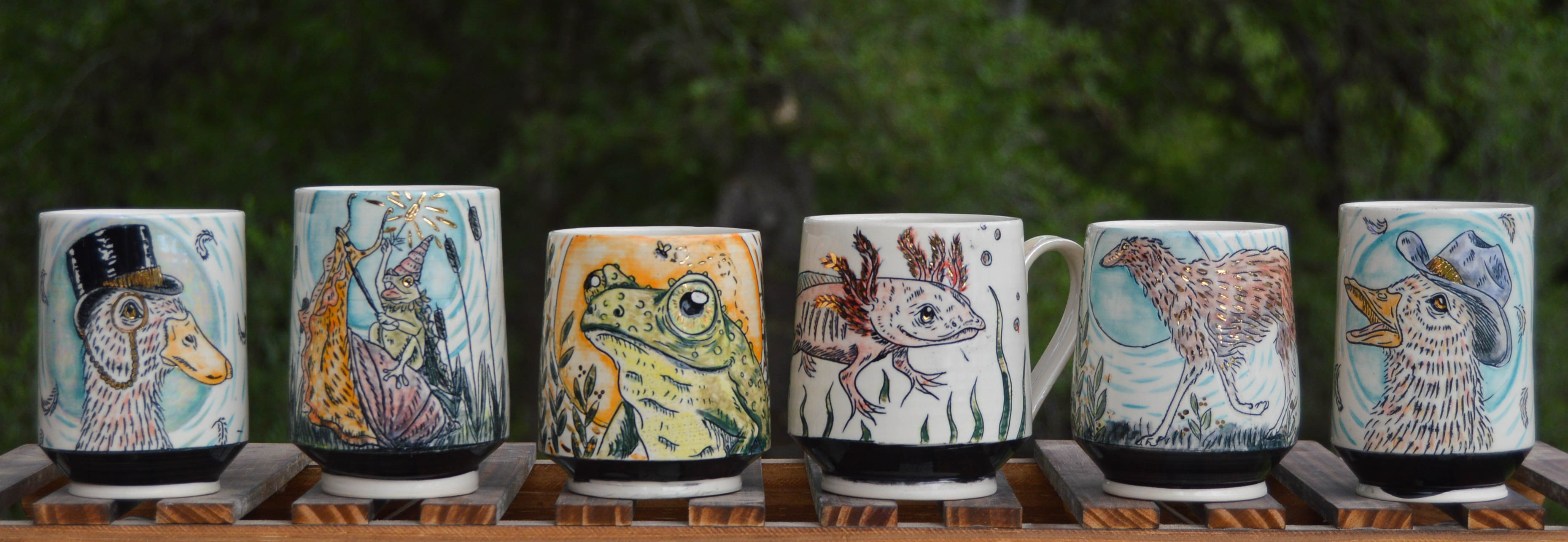 Various handmade porcelain mugs with stylized animal designs