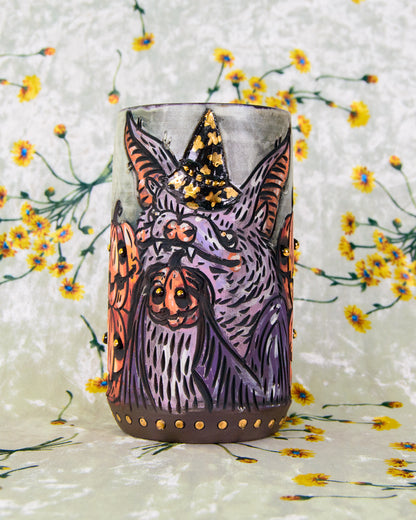 Ceramic mug with a halloween-themed design of a stylized bat with pumpkins