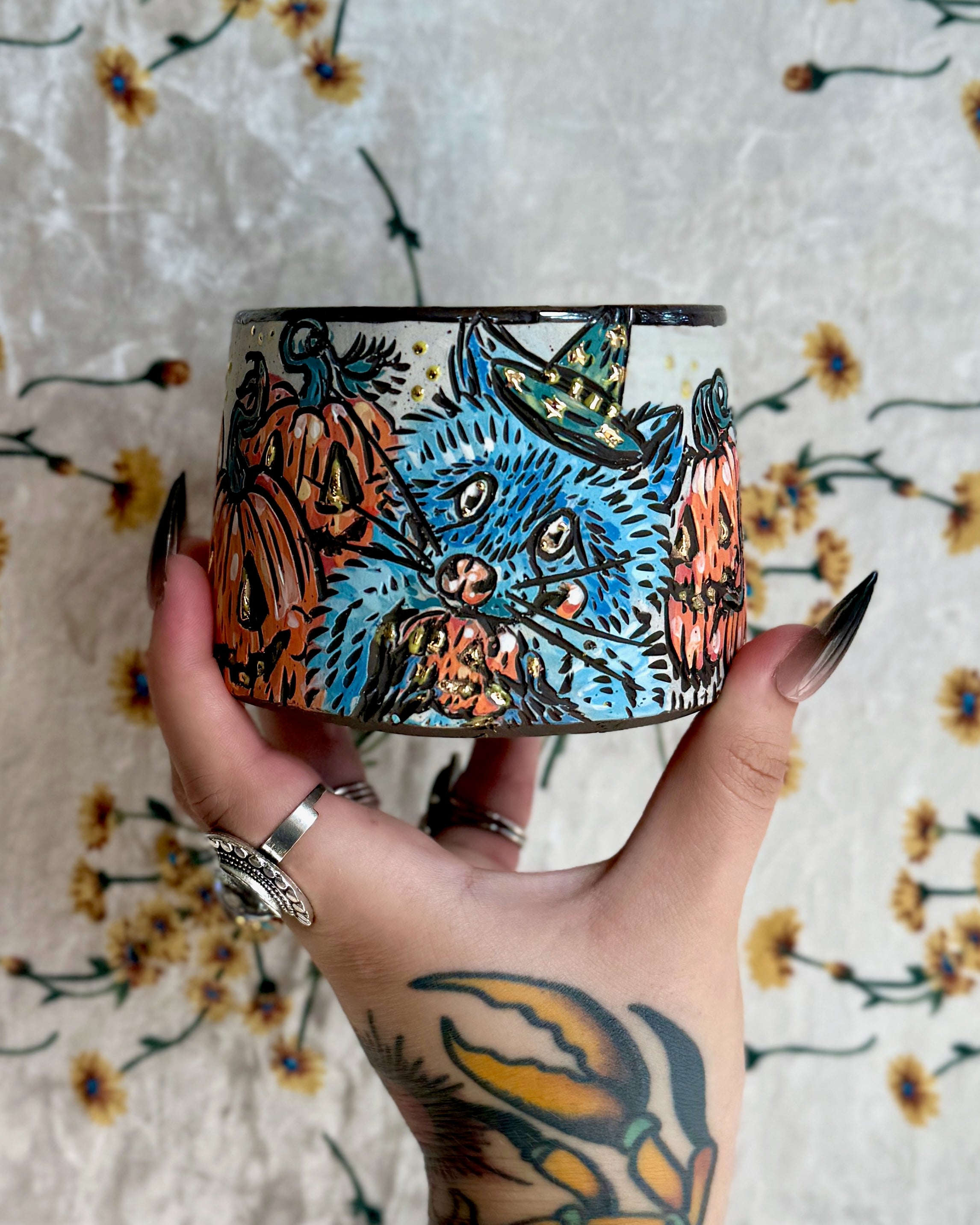 Handmade ceramic stoneware mug with a cartoon raccoon in a pumpkin patch design