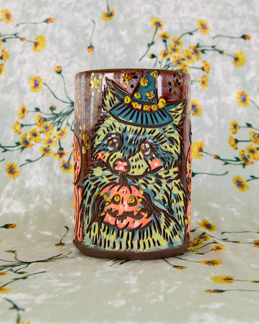 Ceramic mug with a colorful raccoon design on a floral background