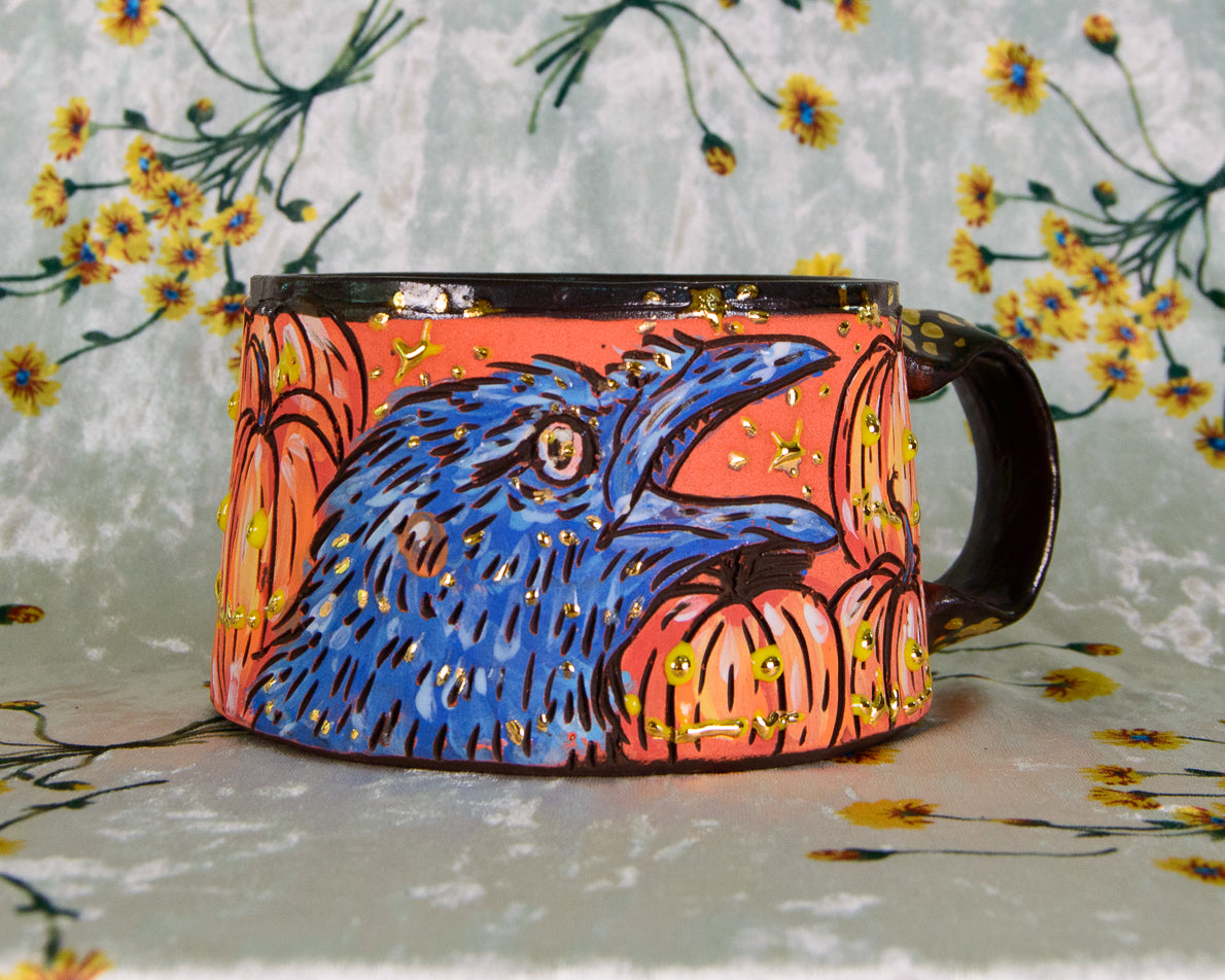 Handmade ceramic stoneware mug with a cute design of crows in a patch of smiling pumpkins
