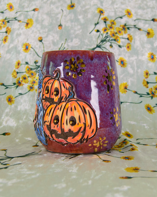 Ceramic cup with cartoon pumpkins on a floral colorful purple background