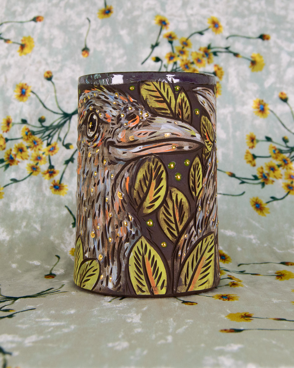Ceramic mug with purple crow designs on a floral background