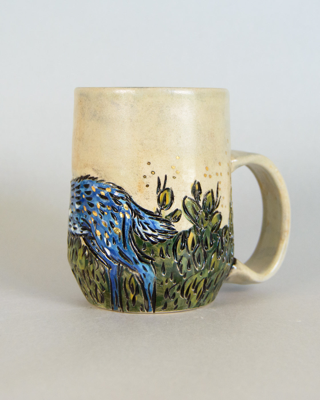 ceramic mug with a deer and bush design
