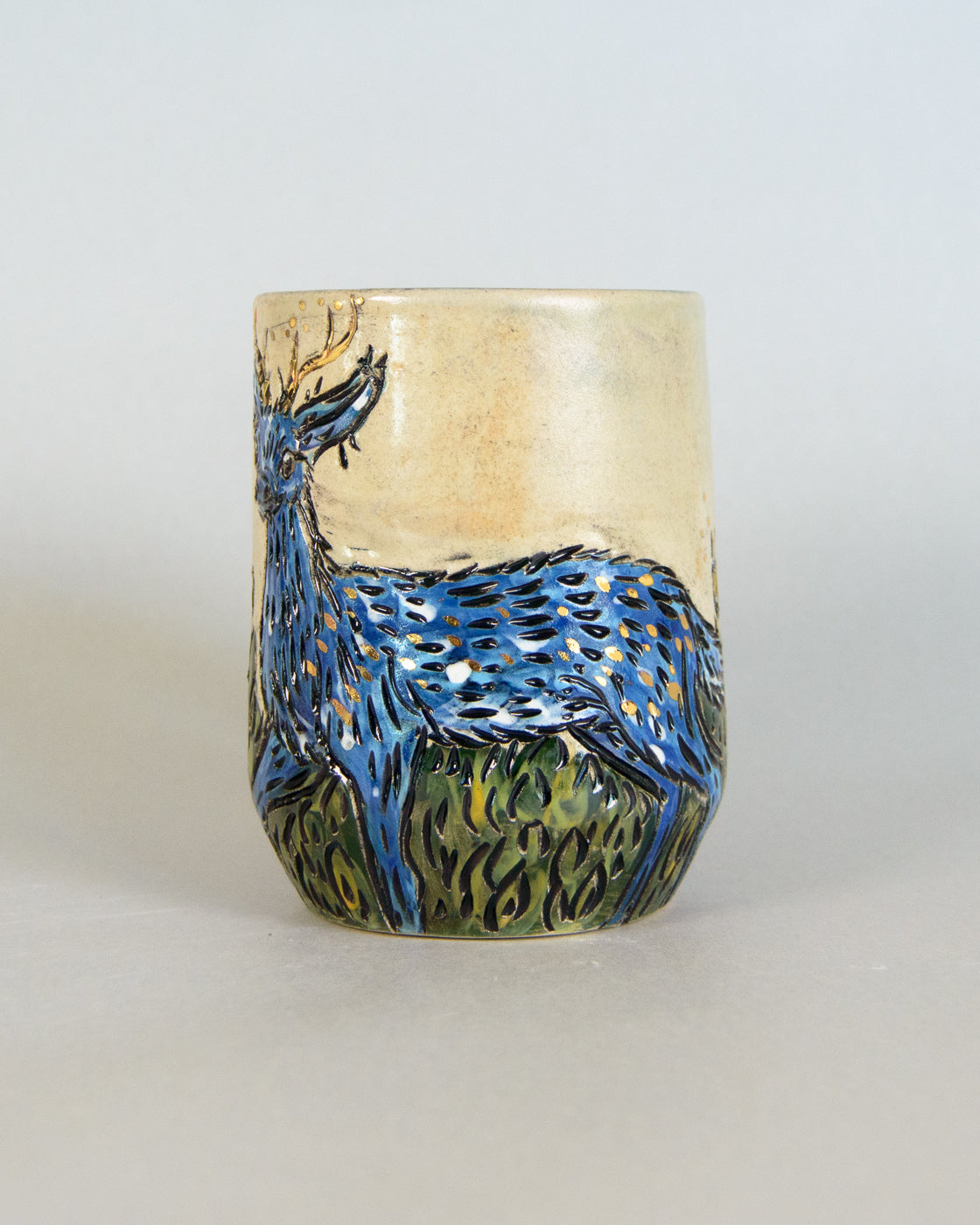 Ceramic mug with a blue deer design on a white background